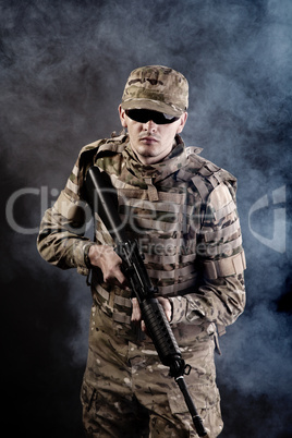 Soldier with a rifle on a black background