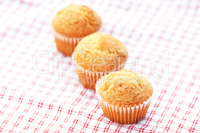 three muffins on plaid fabric