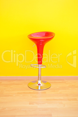 bar chair against a yellow wall in the apartment