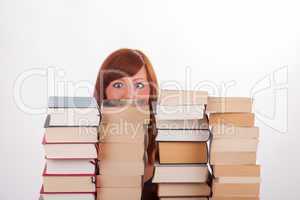 Eine junge Frau sitzt hinter einem Berg von Büchern