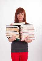 Eine junge schöne Frau trägt viele Bücher