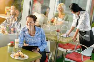 Businesswoman working in lunch break in cafe