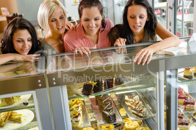 Women friends looking at cakes in cafe