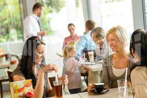 Women friends enjoying a drink at cafe