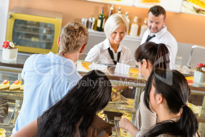People buying cakes at cafeteria queue desserts