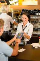 Man paying bill at cafe using card