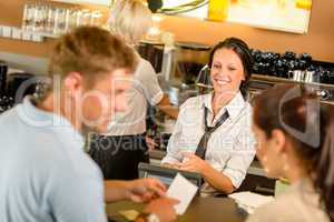 Couple paying bill at cafe cash desk