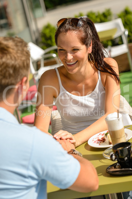 Couple flirting holding hands at cafe bar