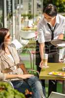 Waitress serve woman latte at cafe bar