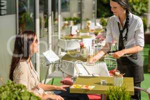 Waitress serve woman latte at cafe bar