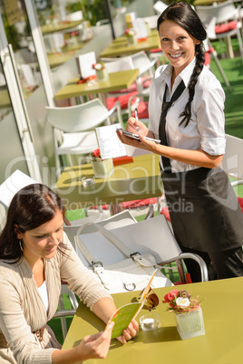 Waitress waiting for woman to order menu