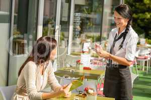 Waitress taking woman's order at cafe bar