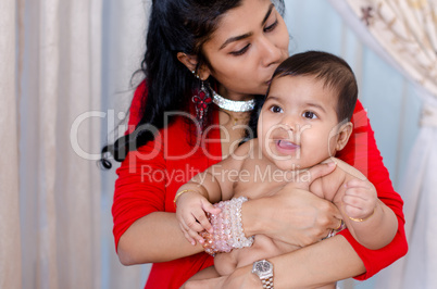 Mother kissing baby girl