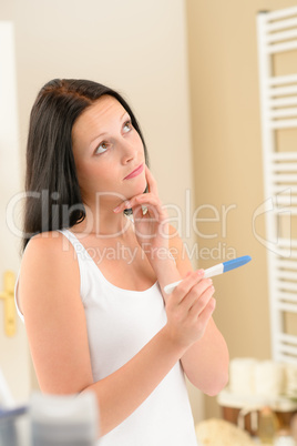 Woman expecting pregnancy test result in bathroom