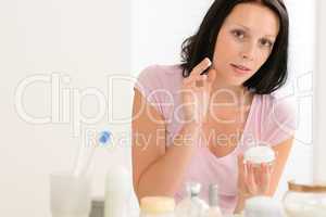 Beauty woman put moisturizer cream in bathroom