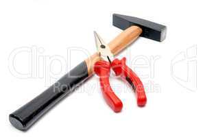 Hammer and flat-nose pliers with red handles isolated over white background