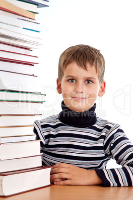 Schoolboy and a heap of books isolated on a white background