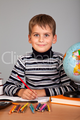 Cute schoolboy is writting