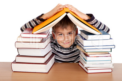 Schoolboy and a heap of books isolated on a white background