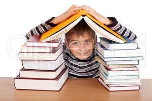 Schoolboy and a heap of books isolated on a white background