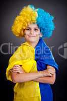 Football fan with  ukrainian flag on a black background