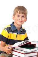 Schoolboy is sitting on books