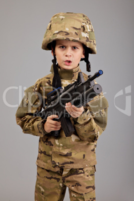 Young boy dressed like a soldier with rifle