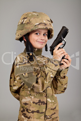 Young boy dressed like a soldier with a gun