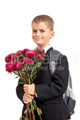 Schoolboy is holding flowers. Back to school