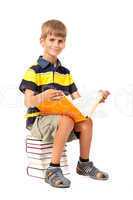 Schoolboy is sitting on books. Back to school