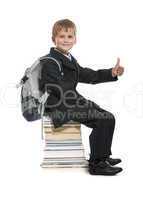 Schoolboy sitting on books