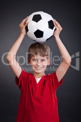 Cute boy is holding a football ball. Soccer ball