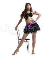 Young woman dance with chair in sexy dress