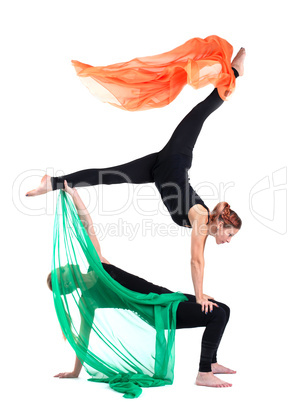 two woman gymnast posing with flying fabric
