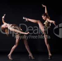 Two girl in gold dance costume posing with fight