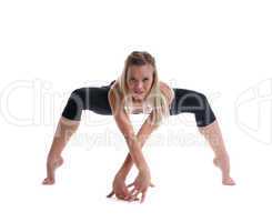 young blond woman stand in spider yoga pose