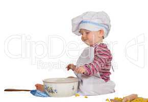 Satisfied little baby chef looking at mixing bowl