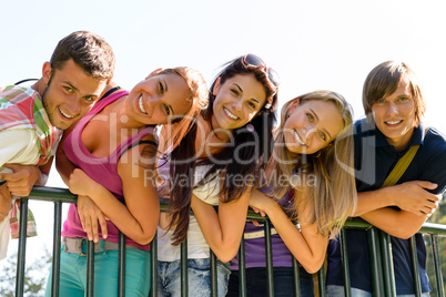 Teens having fun in park leaning fence