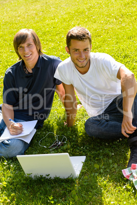 Teens sitting in park with laptop students