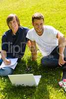 Teens sitting in park with laptop students
