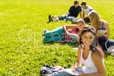Students studying sitting on grass in park