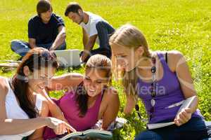 Teens studying in park reading book students
