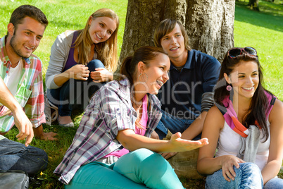 Students relaxing in schoolyard teens meadow park