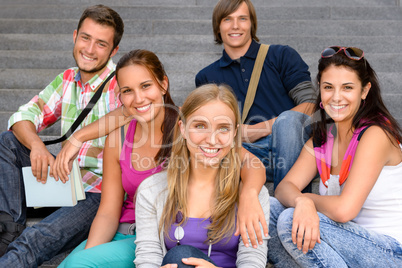 Students sitting on school stairs smiling teens