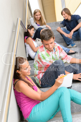 Students talking relaxing on school steps teens
