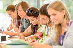 Students writing at high-school exam teens study