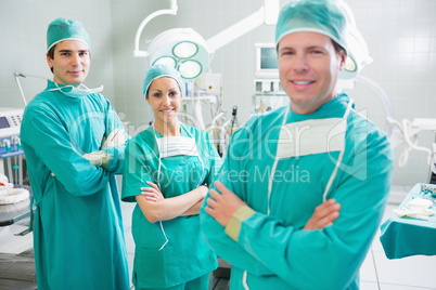 Smiling surgeons looking at camera with crossed arms