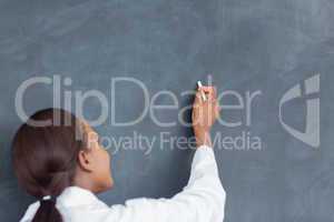 Rear view of a teacher writing on a blackboard