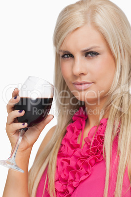 Serious blonde drinking a glass of red wine