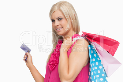 Smiling blonde holding shopping bags and credit card